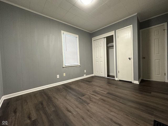 unfurnished bedroom featuring crown molding, dark hardwood / wood-style floors, and a closet