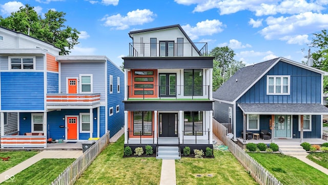 1218 Orange St, Indianapolis, IN 46203 - modern home with a balcony, a sunroom, board and batten siding, and covered porch