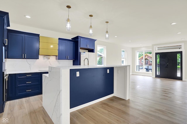 1218 Orange St, Indianapolis, IN 46203 - kitchen featuring light wood-type flooring, blue cabinetry, decorative backsplash, decorative light fixtures, and recessed lighting