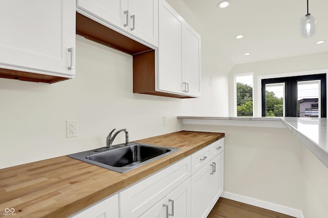 1218 Orange St, Indianapolis, IN 46203 - kitchen with wooden counters, a sink, recessed lighting, and white cabinetry