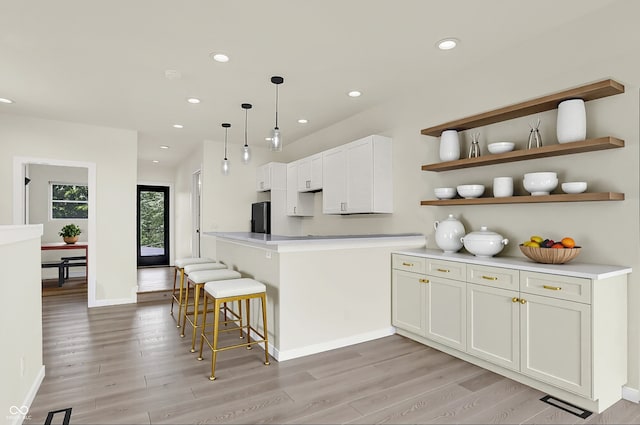 1218 Orange St, Indianapolis, IN 46203 - kitchen with fridge, light wood finished floors, recessed lighting, a peninsula, and a breakfast bar area