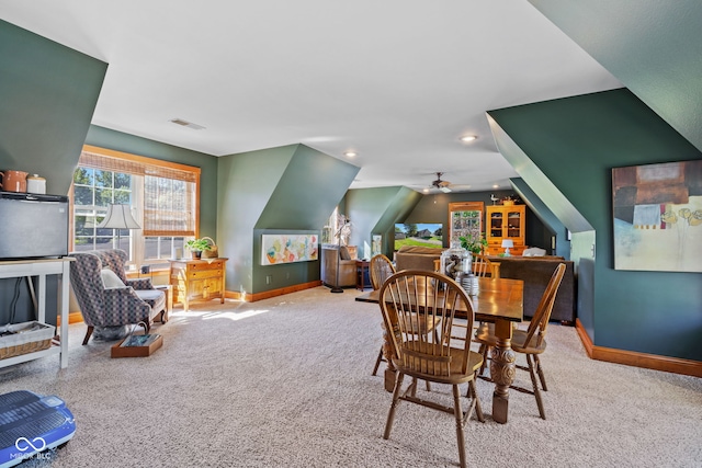 carpeted dining room with vaulted ceiling