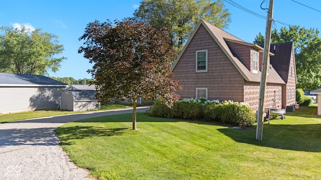 view of side of property with a shed, a yard, and central air condition unit