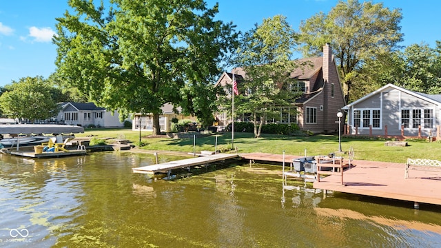 view of dock with a water view and a lawn