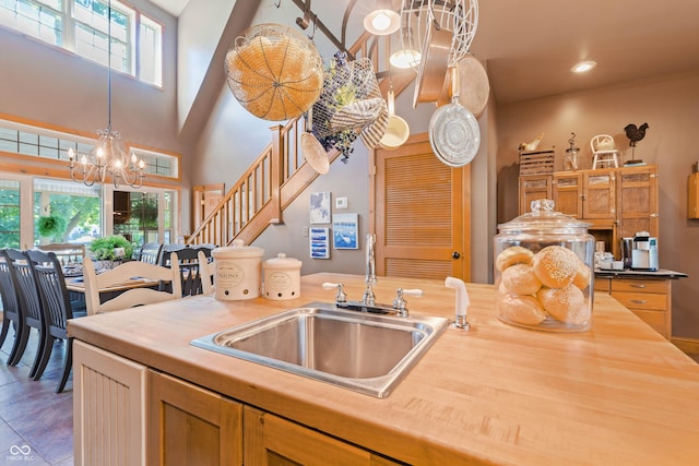 kitchen featuring a healthy amount of sunlight, decorative light fixtures, sink, and a notable chandelier