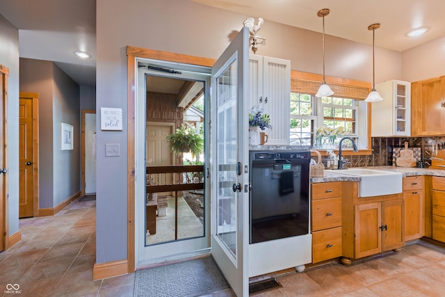 kitchen featuring pendant lighting, sink, oven, backsplash, and light tile patterned floors