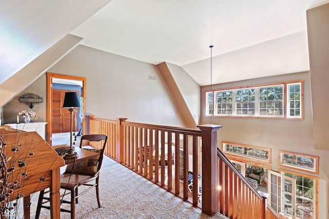 corridor with lofted ceiling and carpet