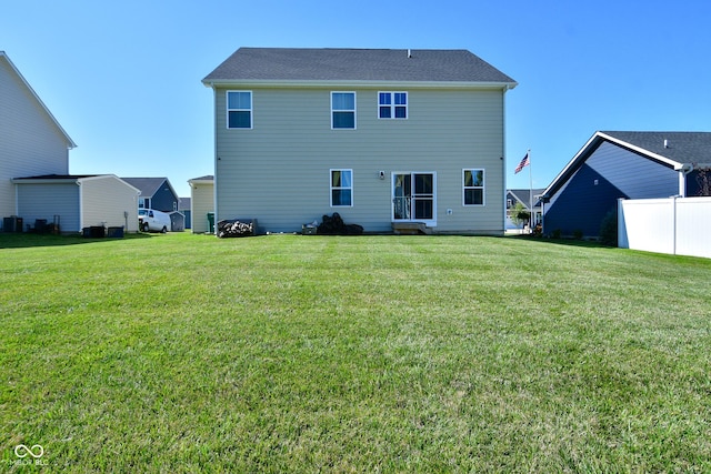 back of property featuring a yard and central AC