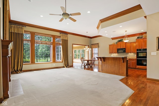 kitchen with hanging light fixtures, a breakfast bar, a center island, and black appliances