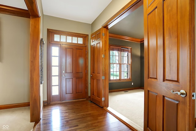 foyer entrance featuring crown molding and hardwood / wood-style floors