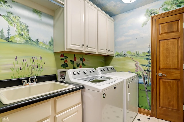 washroom with cabinets, washer and dryer, and sink