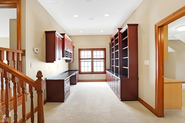 carpeted home office featuring built in desk