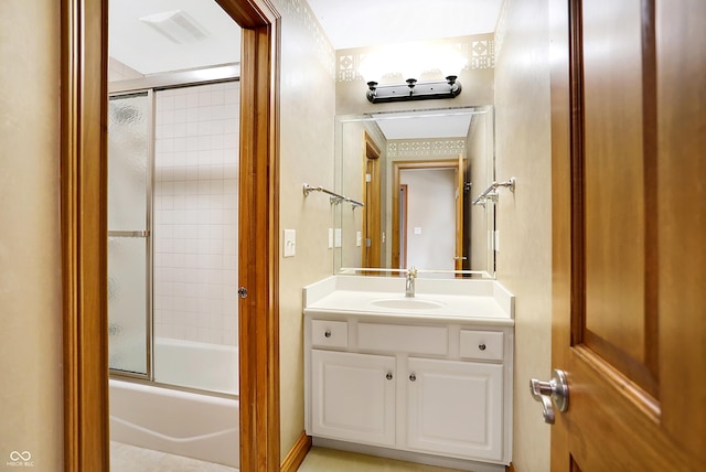 bathroom with combined bath / shower with glass door and vanity