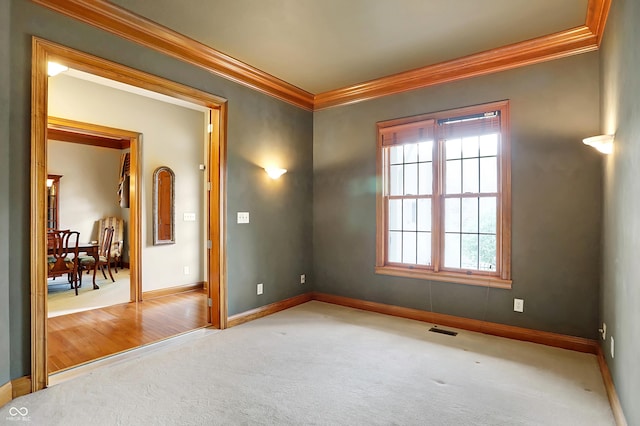 carpeted empty room featuring crown molding