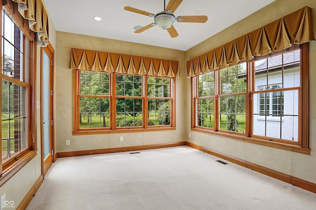 unfurnished sunroom with ceiling fan