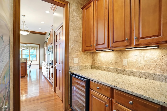 kitchen with crown molding, light hardwood / wood-style flooring, light stone countertops, tasteful backsplash, and beverage cooler