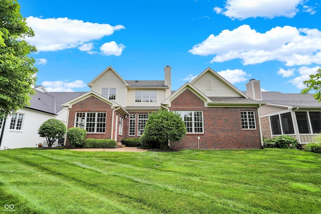 rear view of house with a sunroom and a yard