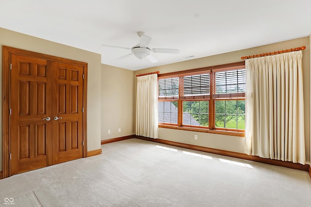 unfurnished bedroom featuring ceiling fan and light carpet