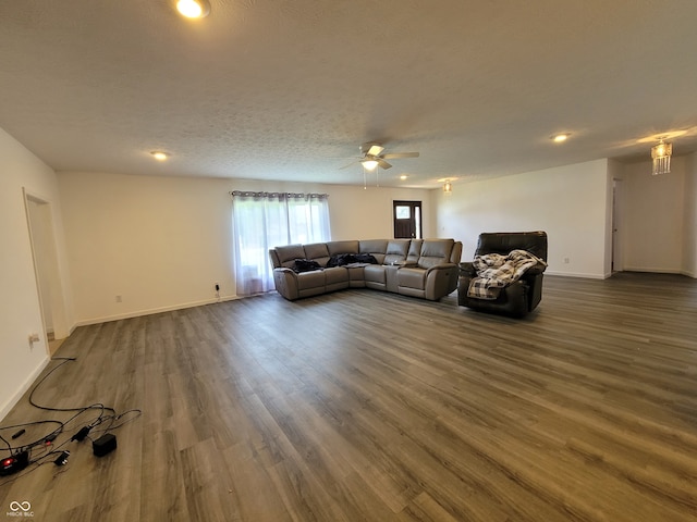 living room with ceiling fan, a textured ceiling, and dark hardwood / wood-style floors