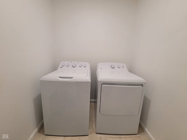 washroom featuring washer and clothes dryer and light tile patterned floors