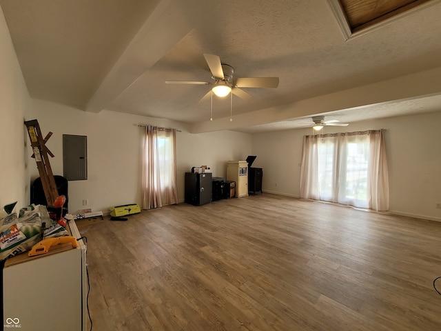 misc room with ceiling fan, hardwood / wood-style flooring, a textured ceiling, and electric panel