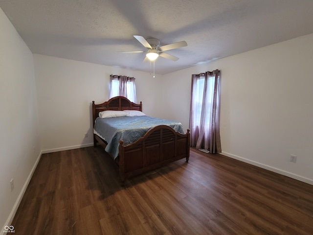 bedroom with ceiling fan, a textured ceiling, and dark hardwood / wood-style floors