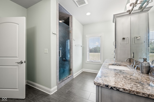 bathroom featuring vanity, an enclosed shower, and tile patterned floors