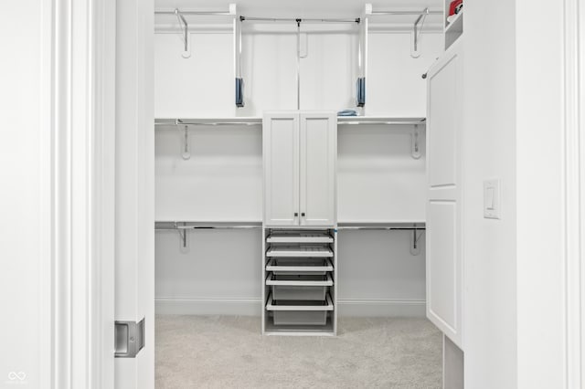 walk in closet featuring light colored carpet