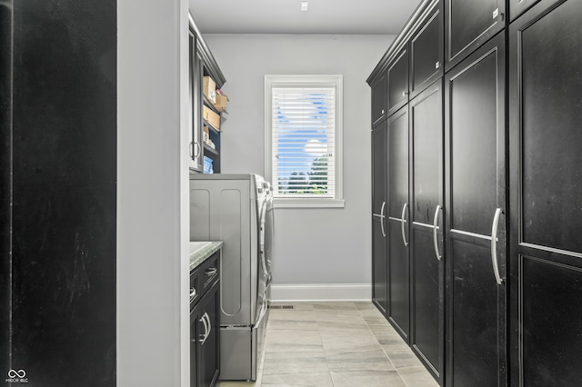 laundry area featuring cabinets, washing machine and clothes dryer, and light tile patterned floors