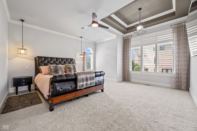 carpeted bedroom featuring crown molding, a raised ceiling, and ceiling fan