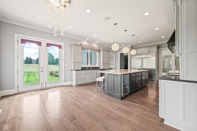 kitchen featuring gray cabinets, beverage cooler, stainless steel built in fridge, and a center island