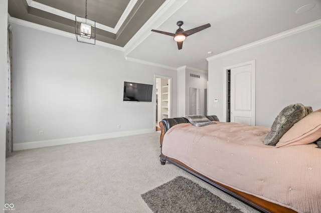 carpeted bedroom featuring ceiling fan, a tray ceiling, ornamental molding, and a closet