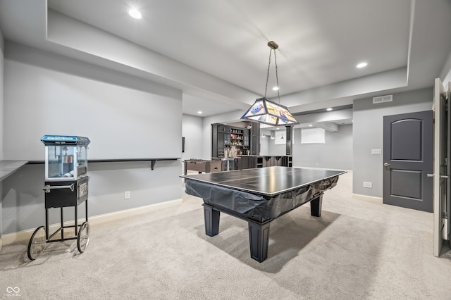 recreation room featuring light colored carpet and a tray ceiling