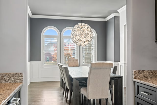 dining room featuring hardwood / wood-style flooring, ornamental molding, and an inviting chandelier