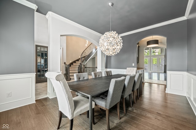 dining room with a notable chandelier, dark hardwood / wood-style flooring, and ornamental molding