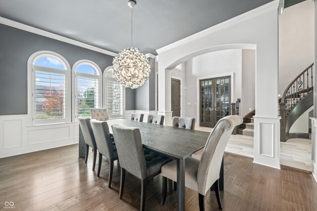 dining space featuring dark hardwood / wood-style floors, a notable chandelier, french doors, and ornamental molding