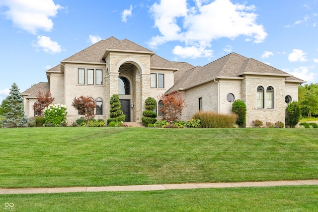 french country inspired facade with a front yard