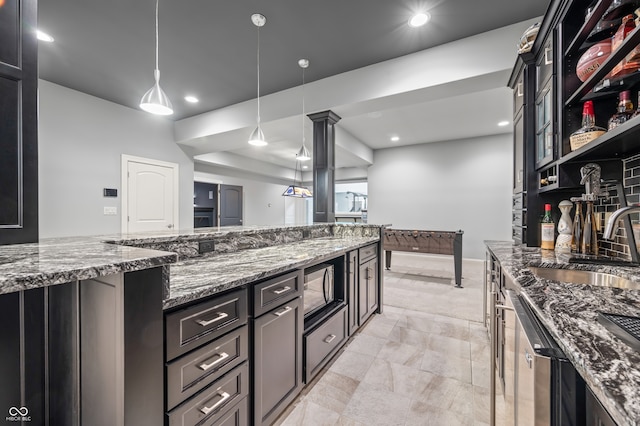 kitchen featuring dark stone counters, sink, pendant lighting, light tile patterned floors, and built in microwave