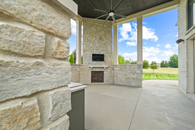 view of patio with an outdoor stone fireplace and ceiling fan