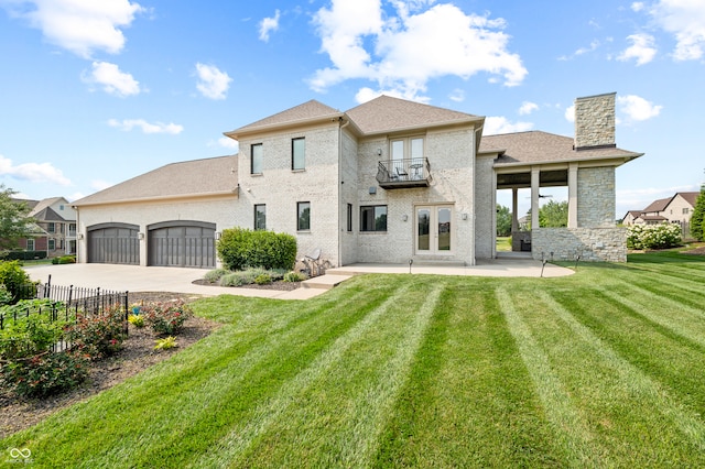 rear view of property with a balcony, french doors, and a lawn