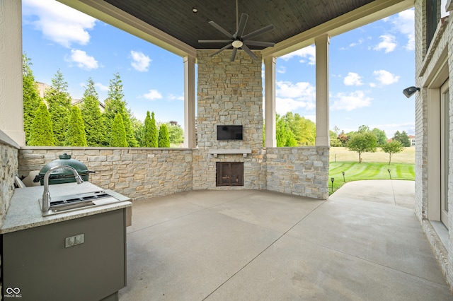 view of patio / terrace featuring area for grilling, an outdoor stone fireplace, and ceiling fan