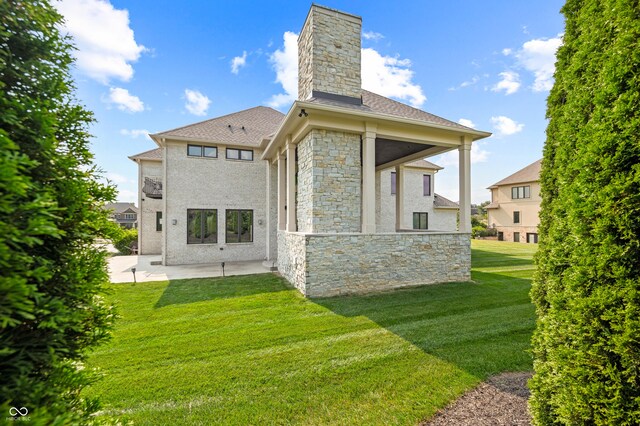 rear view of house featuring a lawn and a patio area