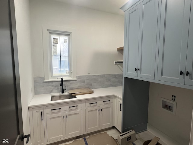 clothes washing area featuring cabinets, hookup for a washing machine, and sink