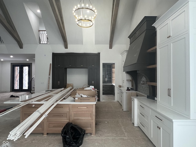 kitchen with white cabinets, beam ceiling, and french doors