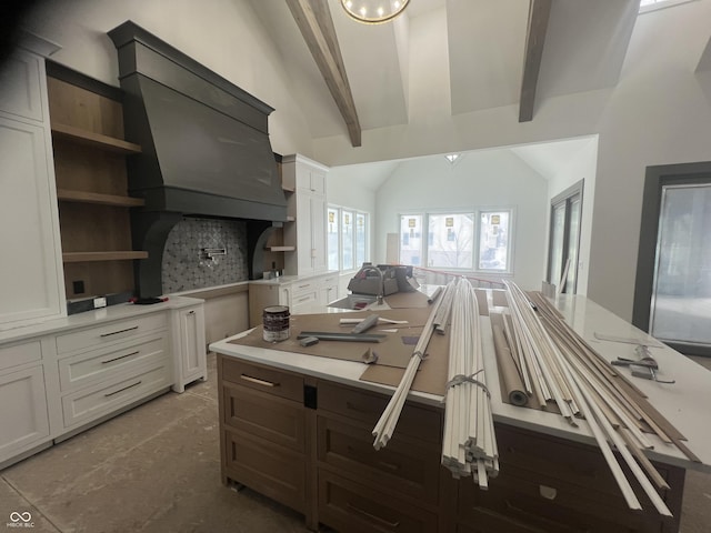 kitchen with white cabinetry, decorative backsplash, and vaulted ceiling with beams