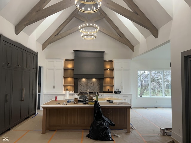 kitchen with an island with sink, a breakfast bar, and white cabinets