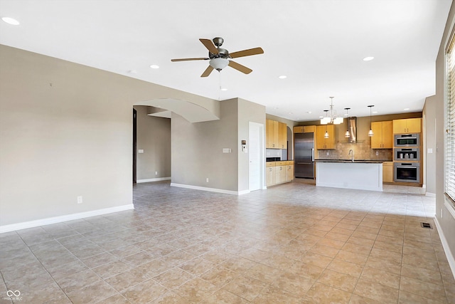 unfurnished living room with ceiling fan with notable chandelier, sink, and light tile patterned floors