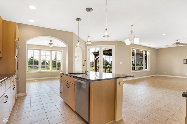 kitchen with stainless steel dishwasher, a center island with sink, ceiling fan with notable chandelier, and sink