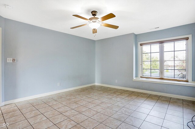 tiled spare room with ceiling fan