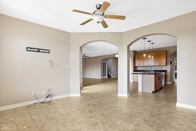 kitchen featuring ceiling fan, hanging light fixtures, dishwasher, and sink